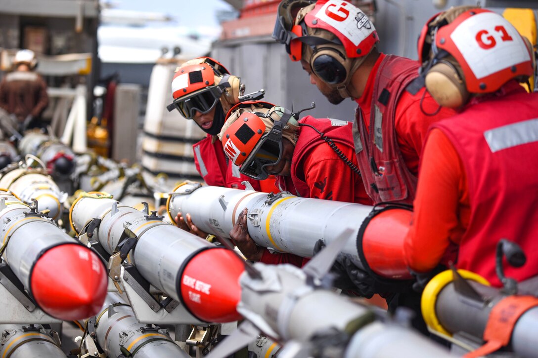 Sailors move ordnance on board the aircraft carrier USS Harry S. Truman.