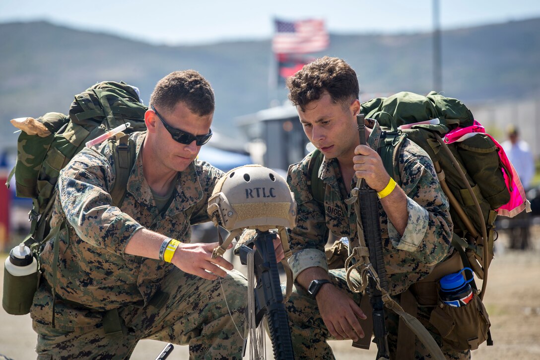 Staff Sgt. Curtis Garrison, left, range scheduler, Headquarters and Support Battalion, Marine Corps Installations-West and Sgt. Austin Diggs, ground radio tech, 9th Communication Battalion, kneel in front of a battlefield cross during the 10th Annual Challenge Recon on Marine Corps Base Camp Pendleton, Calif., May 17, 2018. The Challenge Recon was a 25 mile endurance course where Marines endure rigorous challenges and tests. Each team represented a fallen Marine. (U.S. Marine Corps photo by Cpl. Juan C. Bustos)