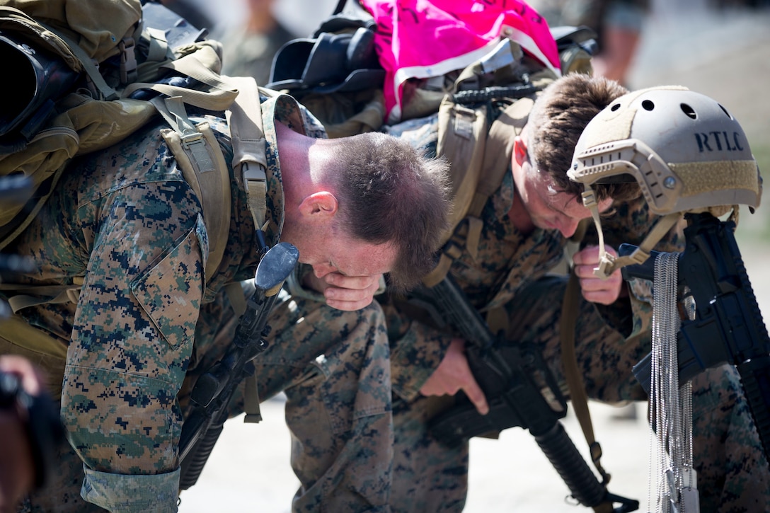 Sgt. Justin M. Logue (left) and Sgt. Scott C. Hunt (right), both assistant team leaders, Alpha Company, 1st Reconnaissance Battalion, kneel in front of a battlefield cross during the 10th Annual Recon Challenge at Marine Corps Base Camp Pendleton, California, May 17, 2018. The Recon Challenge is open to all reconnaissance Marines and Sailors from around the world.