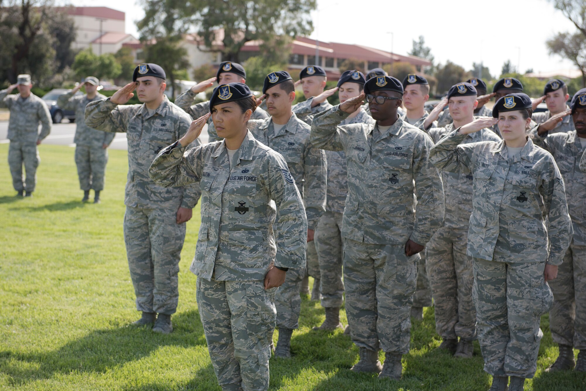 Tech. Sgt. Melody Boutin, 821st Contingency Response Squadron squad leader, leads a formation of 25 Airmen in a salute of the U.S. flag during a retreat ceremony to close out Police Week May 18, 2018 at Travis Air Force Base, Calif. The ceremony featured a roll call for 27 fallen Airmen, the playing of Taps and the ceremonious folding of the American flag. (U.S. Air Force photo by Tech. Sgt. James Hodgman)