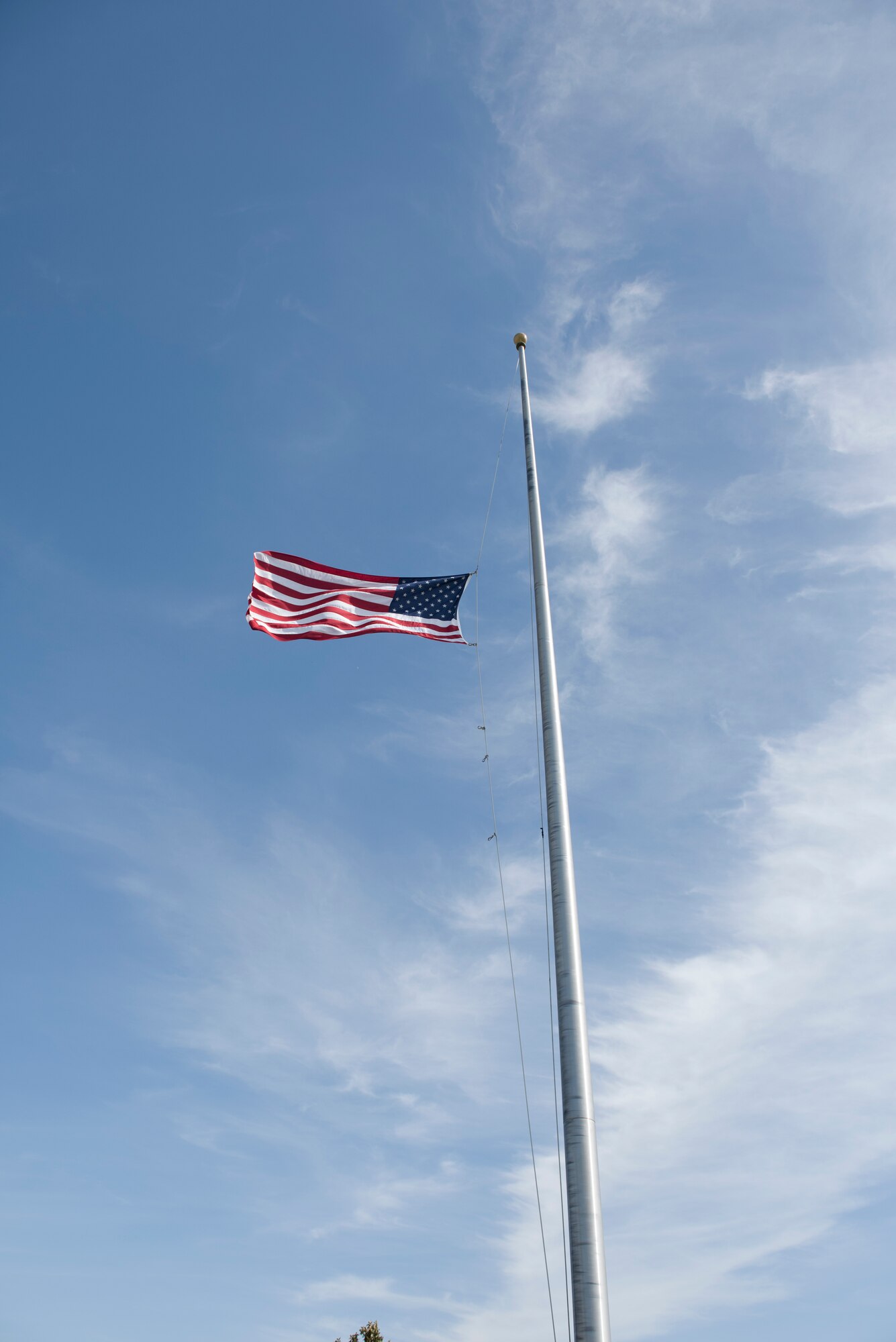The American flag is lowered during a retreat ceremony to close out Police Week May 18, 2018 at Travis Air Force Base, Calif. The ceremony featured a roll call for 27 fallen Airmen, the playing of Taps and the ceremonious folding of the American flag. (U.S. Air Force photo by Tech. Sgt. James Hodgman)