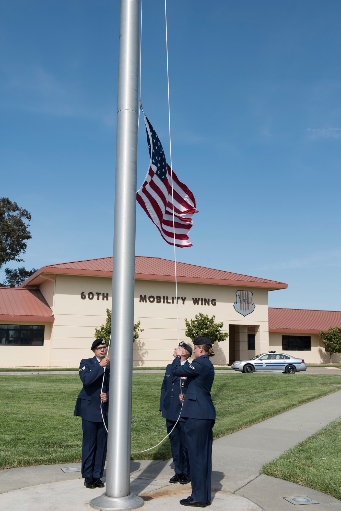 Airmen from the 60th Security Forces Squadron lower the American flag during a retreat ceremony to close out Police Week May 18, 2018 at Travis Air Force Base, Calif. The ceremony featured a roll call for 27 fallen Airmen, the playing of Taps and the ceremonious folding of the American flag. (U.S. Air Force photo by Tech. Sgt. James Hodgman)