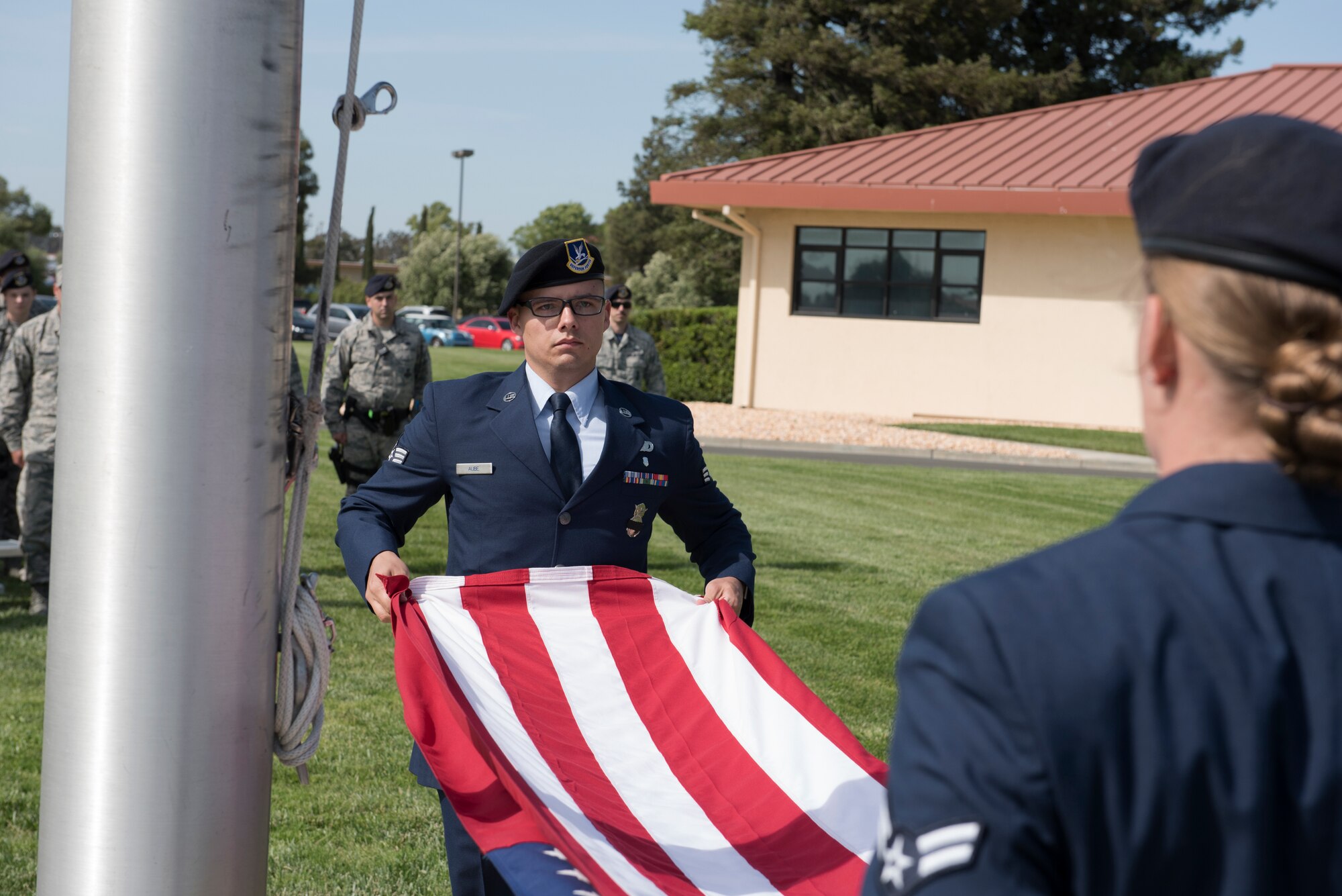 Senior Airman Robert Aube, 60th Security Forces Squadron installation patrolman, prepares to fold the American flag during a retreat ceremony to close out Police Week May 18, 2018 at Travis Air Force Base, Calif. The ceremony featured a roll call for 27 fallen Airmen, the playing of Taps and the ceremonious folding of the American flag. (U.S. Air Force photo by Tech. Sgt. James Hodgman)
