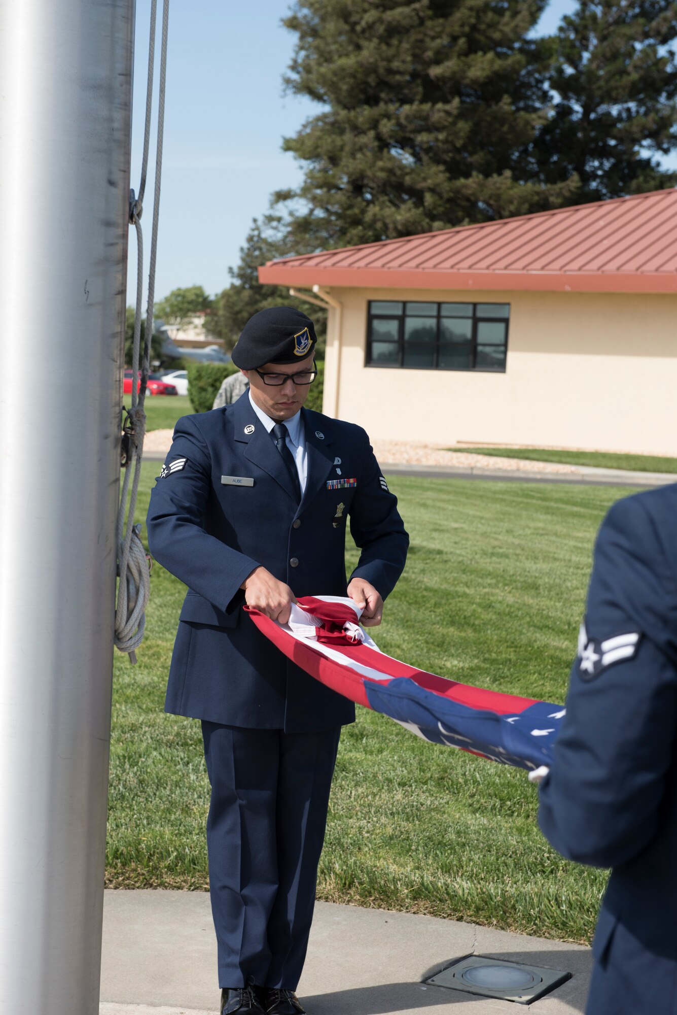 Senior Airman Robert Aube, 60th Security Forces Squadron installation patrolman, folds the American flag during a retreat ceremony to close out Police Week May 18, 2018 at Travis Air Force Base, Calif. The ceremony featured a roll call for 27 fallen Airmen, the playing of Taps and the ceremonious folding of the American flag. (U.S. Air Force photo by Tech. Sgt. James Hodgman)
