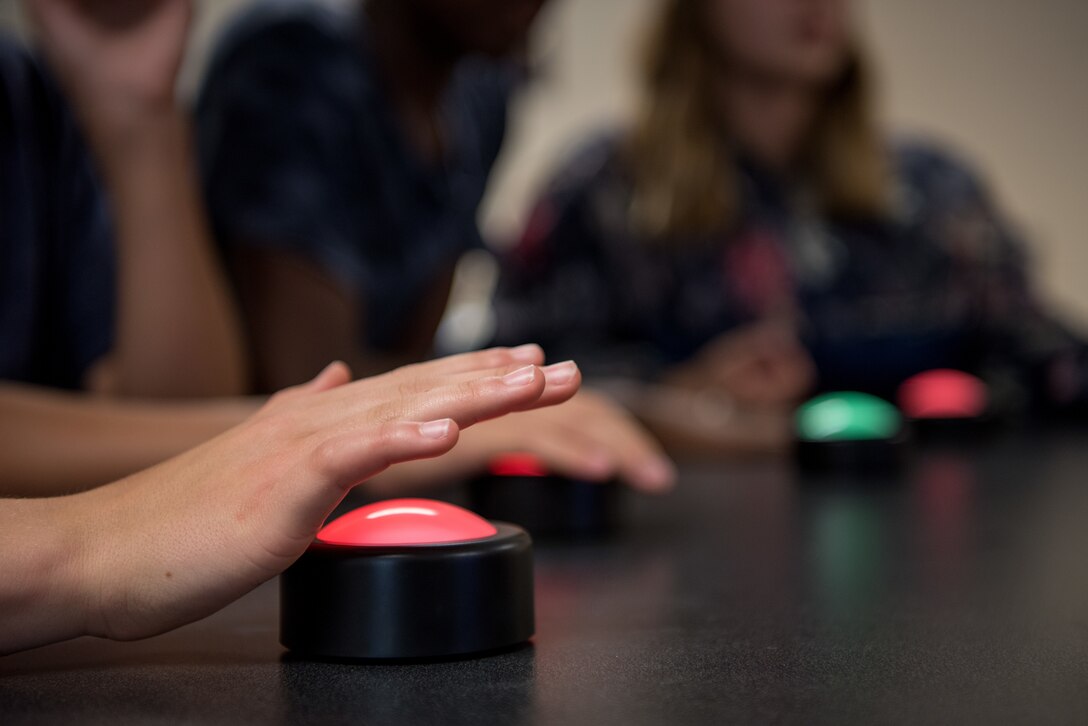 A teenager quickly presses a buzzer in an attempt to answer a jeopardy question, May 18, 2018, at Seymour Johnson Air Force Base, North Carolina.