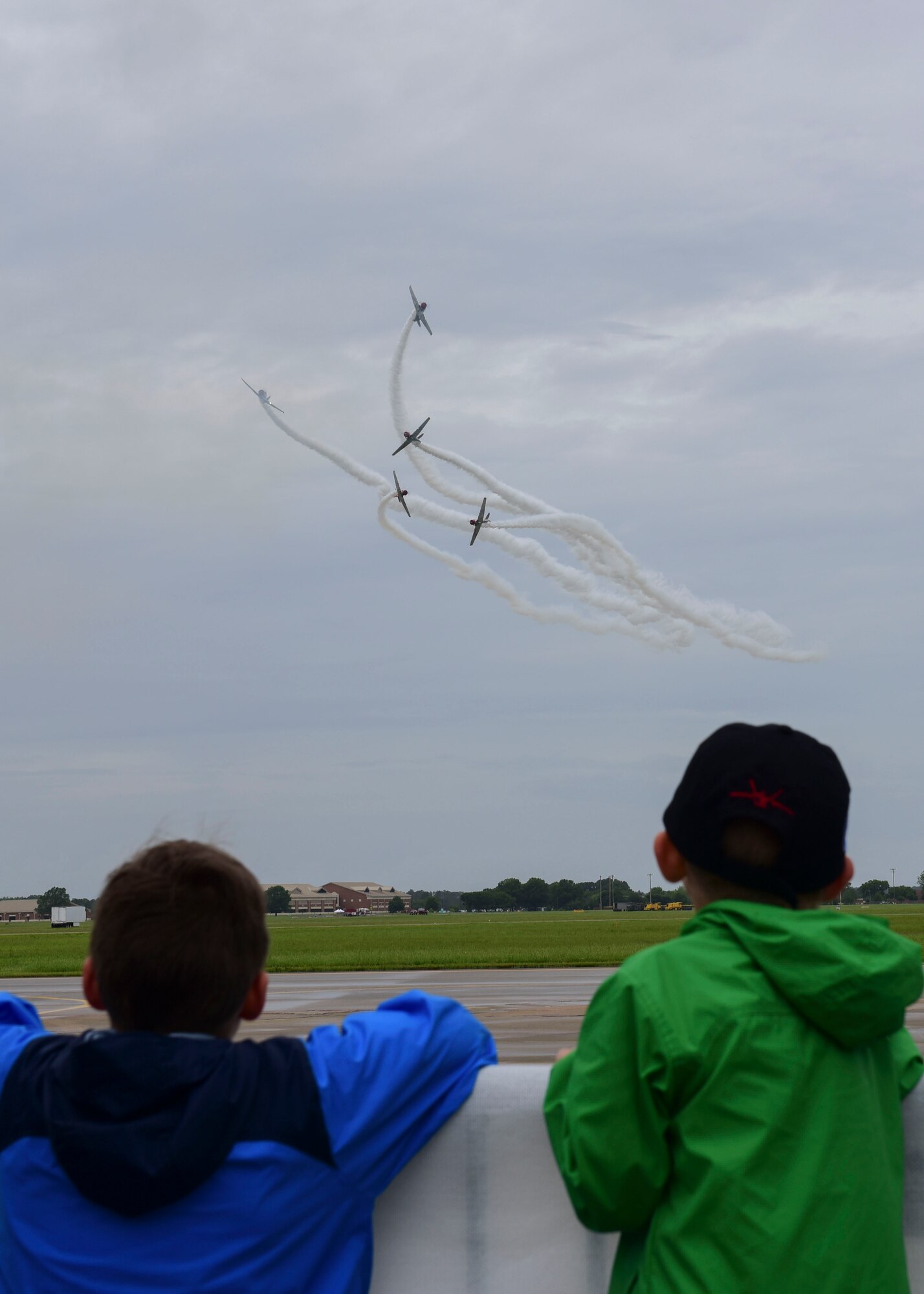 Children watch the Geico Skytypers perform during the AirPower Over Hampton Roads JBLE Air and Space Expo at Joint Base Langley-Eustis, Virginia, May 19, 2018. The Geico Skytypers team consists of six vintage U.S. Navy SNJ trainers that display tactical maneuvers used during World War II and the Korean War. (U.S. Air Force photo by Airman 1st Class Monica Roybal)