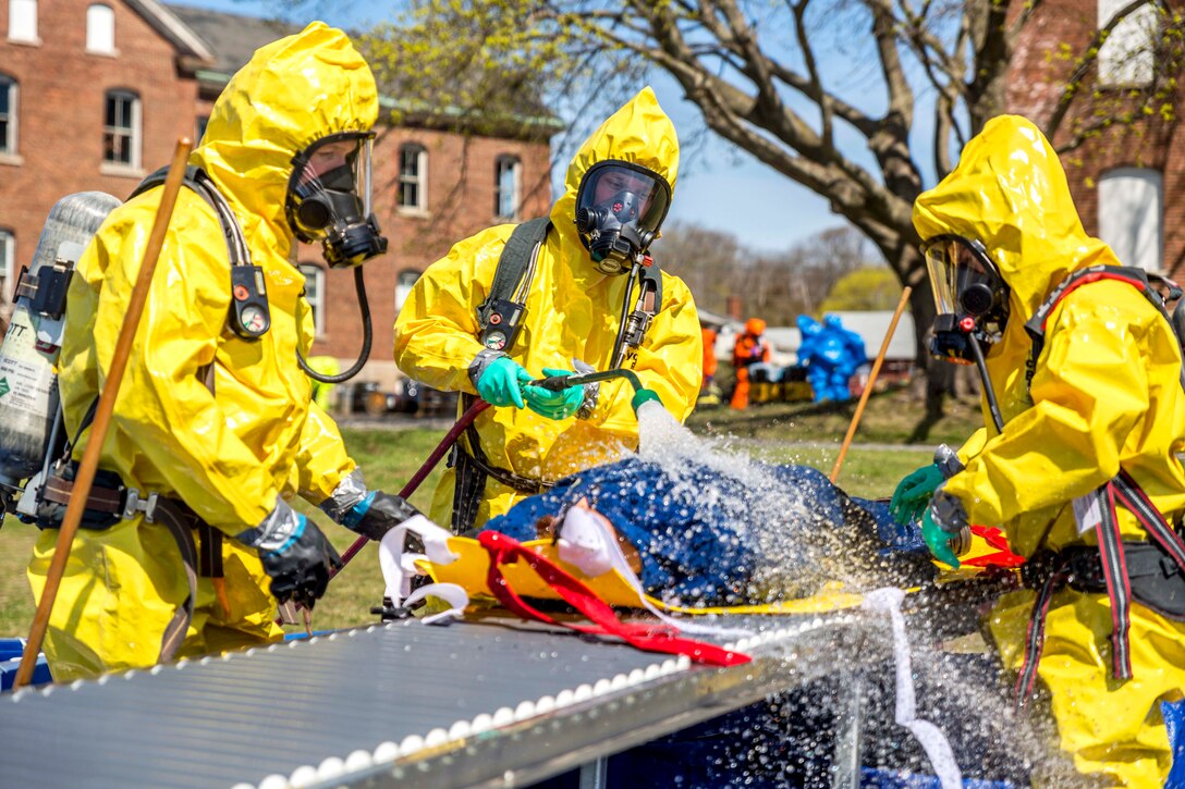 Firefighters decontaminate suits after identifying several hazardous materials.