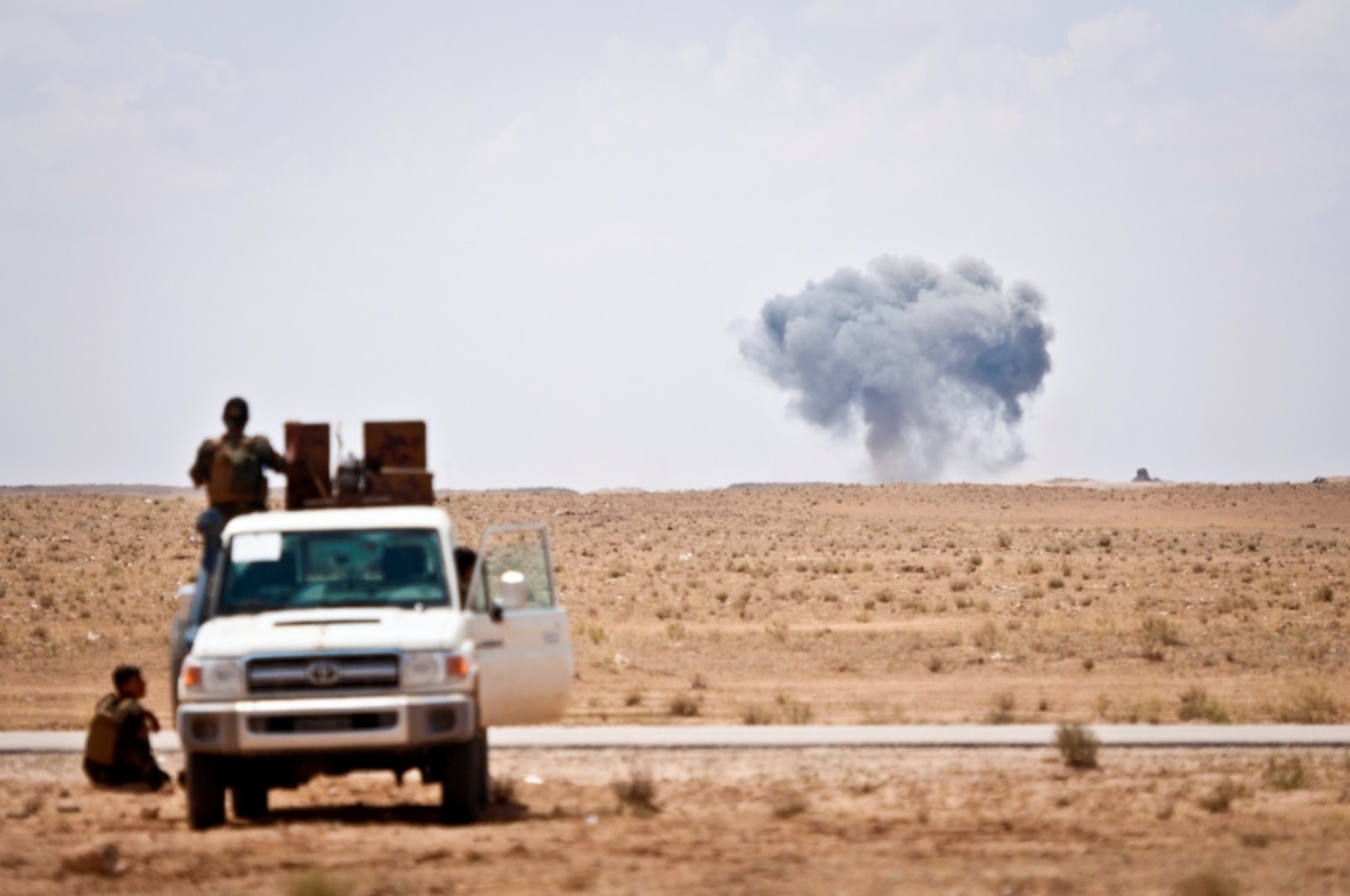 Syrian Democratic Forces watch as a coalition airstrike hits its target on a known Islamic State of Iraq and Syria location near the Iraq-Syria border.