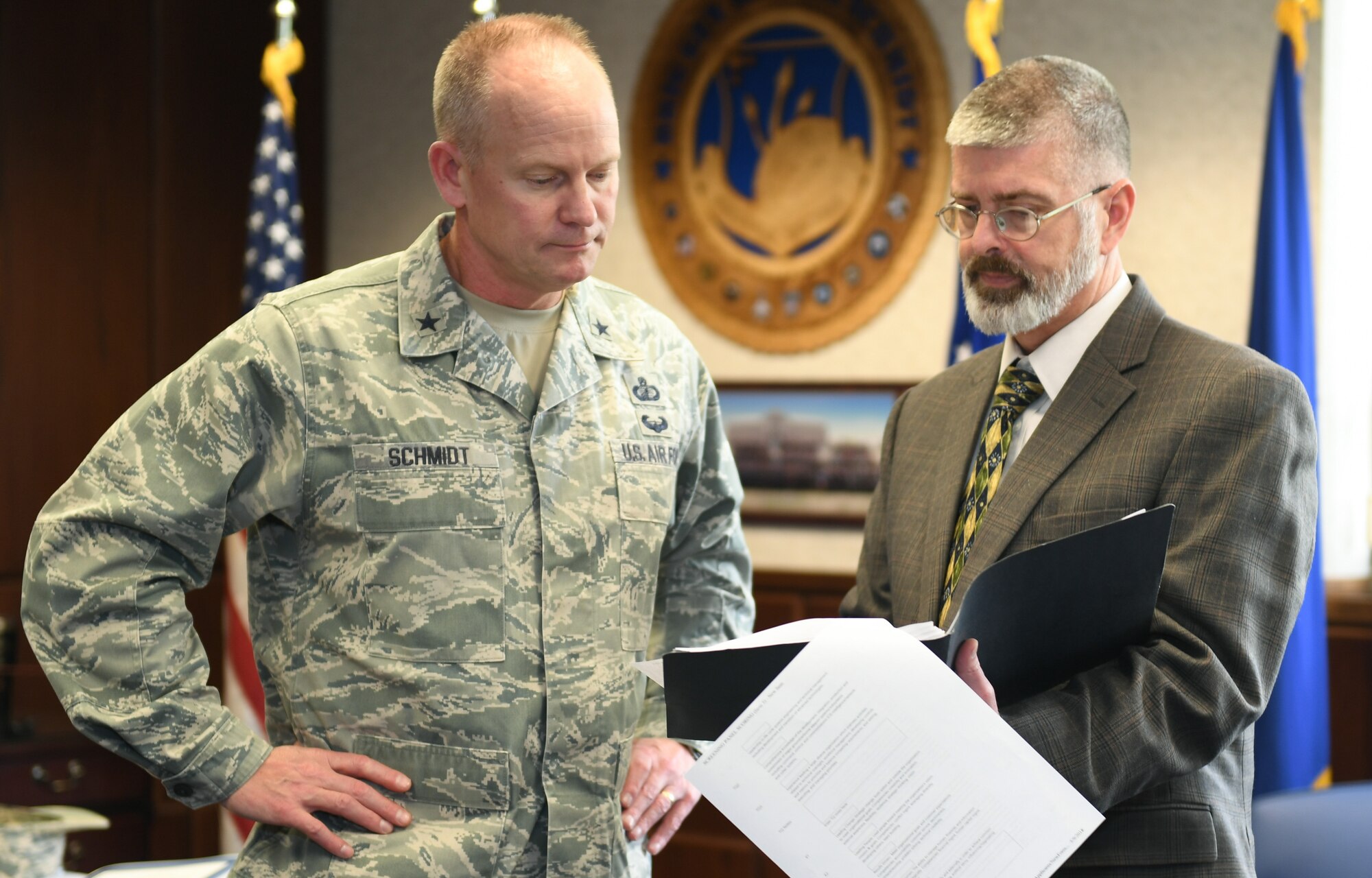 Program Executive Officer for Command, Control, Communications, Intelligence and Networks Brig. Gen. Michael Schmidt looks over acquisition strategies with his deputy, Scott Owens, at Hanscom Air Force Base, Mass., Friday, May 18. Schmidt and Owens recently took over leadership of the C3I&N directorate in April and say they are working towards enabling a workforce which acquires systems at the speed technology evolves. (U.S. Air Force Photo by Todd Maki)