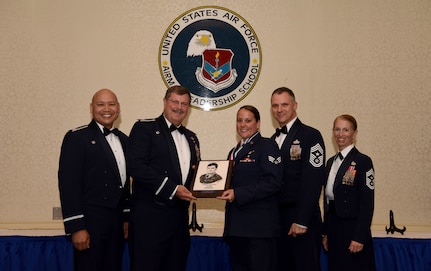 Senior Airman Brittany Korb, center, 315th Aeromedical Evacuation Squadron aeromedical evacuation technician assigned to the , receives the John L. Levitow Award from base leadership (from left to right) Col. Jimmy Canlas, 437th Airlift Wing commander, Col. Gregory Gilmour, 315th Airlift Wing commander, Chief Master Sgt. Mark Barber, 315th AW command chief and Chief Master Sgt. Jennifer Kersey, 437th AW command chief, during an Airman Leadership School graduation ceremony at the Charleston Club May 18, 2018.