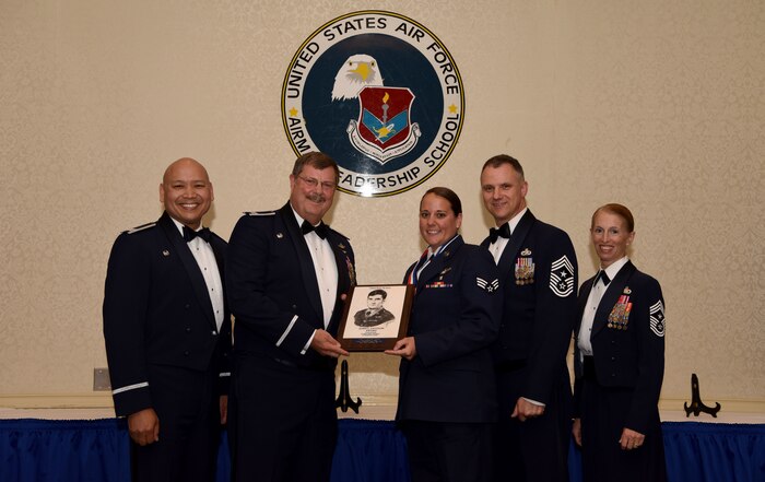 Senior Airman Brittany Korb, center, 315th Aeromedical Evacuation Squadron aeromedical evacuation technician assigned to the , receives the John L. Levitow Award from base leadership (from left to right) Col. Jimmy Canlas, 437th Airlift Wing commander, Col. Gregory Gilmour, 315th Airlift Wing commander, Chief Master Sgt. Mark Barber, 315th AW command chief and Chief Master Sgt. Jennifer Kersey, 437th AW command chief, during an Airman Leadership School graduation ceremony at the Charleston Club May 18, 2018.