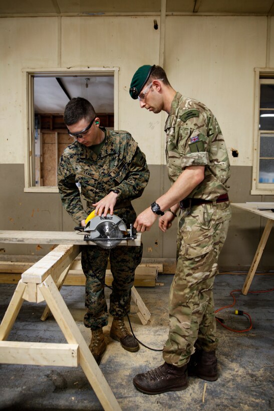 British Army Spr. Mark R. Maton, commando with 131 Commando Squadron Royal Engineers, British Army, teaches U.S. Marine Lance Cpl. Cody A. Evans, combat engineer with Engineer Company C, 6th Engineer Support Battalion, 4th Marine Logistics Group, how to use a circular saw power tool at a construction site during exercise Red Dagger at Fort Indiantown Gap, Pa., May 19, 2018.