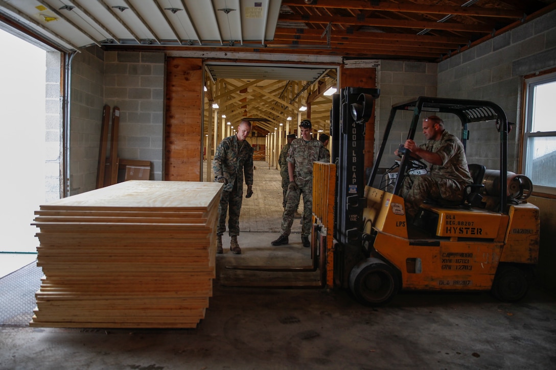 U.S. Marine Lance Cpl. Matthew P. Winter, combat engineer with Engineer Company C, 6th Engineer Support Battalion, 4th Marine Logistics Group, ground guides British Army Lance Cpl. Timothy M. Bourne, commando with 131 Commando Squadron Royal Engineers, British Army, as he operates a forklift at a construction site during exercise Red Dagger at Fort Indiantown Gap, Pa., May 19, 2018.