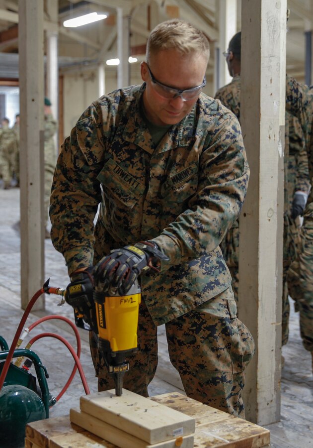 U.S. Marine Cpl. Michael C. Thweatt, combat engineer with Bridge Company C, 6th Engineer Support Battalion, 4th Marine Logistics Group, practices using a nail gun at a construction site during exercise Red Dagger at Fort Indiantown Gap, Pa., May 19, 2018. Exercise Red Dagger is a bilateral training exercise that gives Marines an opportunity to exchange tactics, techniques and procedures as well as build working relationships with their British counterparts. (U.S. Marine Corps photo by Sgt. Melanie Wolf/Released)