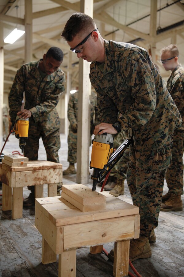 U.S. Marines Lance Cpl. Michael D. Foy (left), motor vehicle operator with Bridge Company B, 6th Engineer Support Battalion, 4th Marine Logistics Group, and Lance Cpl. Ryan W. Carlson (right), field radio operator with Headquarters and Service Company, 6th ESB, 4th MLG, practice using nail guns at a construction site during exercise Red Dagger at Fort Indiantown Gap, Pa., May 19, 2018. Exercise Red Dagger is a bilateral training exercise that gives Marines an opportunity to exchange tactics, techniques and procedures as well as build working relationships with their British counterparts. (U.S. Marine Corps photo by Sgt. Melanie Wolf/Released)