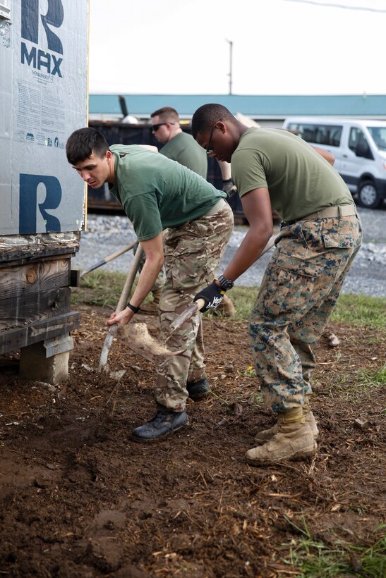 British Army Spr. Adam Foreman, commando with 131 Commando Squadron Royal Engineers, British Army and U.S. Marine Lance Cpl. Jerricko L. Willins, combat engineer with Bridge Company C, 6th Engineer Support Battalion, 4th Marine Logistics Group, level dirt with shovels at a construction site during exercise Red Dagger at Fort Indiantown Gap, Pa., May 20, 2018.