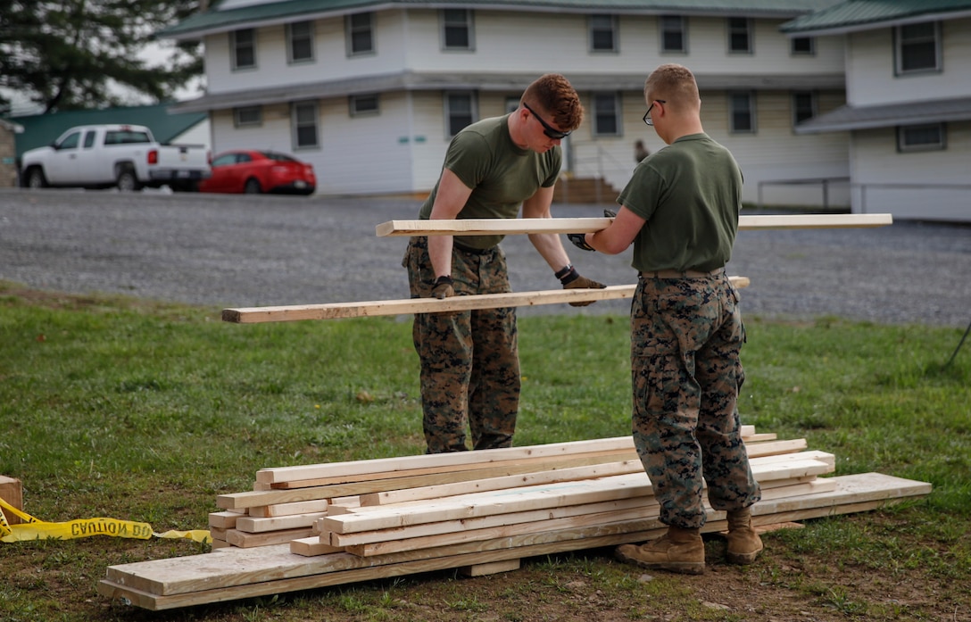 U.S. Marines Lance Cpl. Jason P. McWhinnie (left), field radio operator with Engineer Support Company, 6th Engineer Support Battalion, 4th Marine Logistics Group, and Private First Class Austin T. Roberts (right), combat engineer with Bridge Company C, 6th ESB, 4th MLG, stack wooden planks at a construction site during exercise Red Dagger at Fort Indiantown Gap, Pa., May 20, 2018.