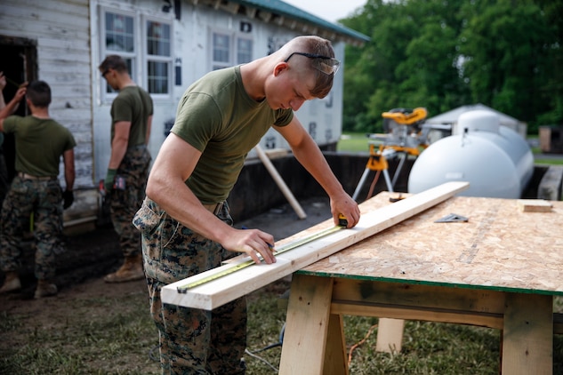 U.S. Marine Private First Class Jeffrey Beasley, combat engineer with Engineer Company C, 6th Engineer Support Battalion, 4th Marine Logistics Group, measures and marks a cut line on a plank at a construction site during exercise Red Dagger at Fort Indiantown Gap, Pa., May 20, 2018.