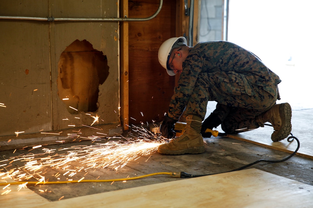 U.S. Marine Lance Cpl. Casey W. Holle, combat engineer with Engineer Company C, 6th Engineer Support Battalion, 4th Marine Logistics Group, uses a grinder to level the ground at a construction site during exercise Red Dagger at Fort Indiantown Gap, Pa., May 20, 2018.