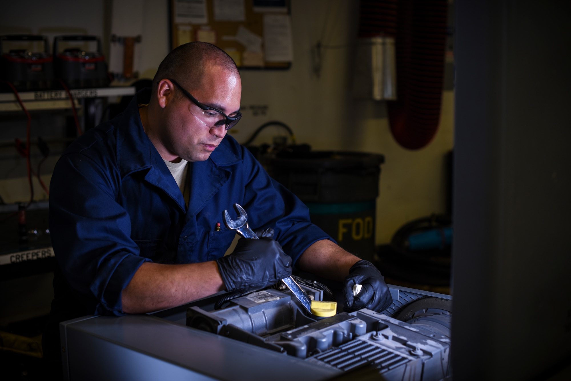 Tech. Sgt. Jason Cadmus tightens hardware on the engine block of a munitions loading vehicle during a service inspection