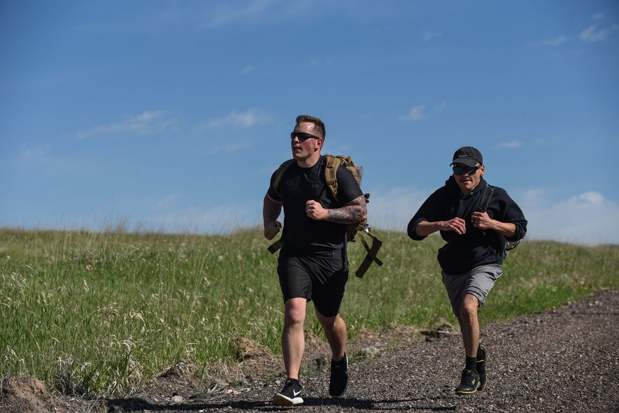 Senior Airman Tyler Hiltner, 90th Security Forces Group defender, and Senior Airman Francisco Chavez, 90th SFG defender, race to the finish line of the six-mile run, walk or ruck for police week, May 17, 2018, on F.E. Warren Air Force Base, Wyo. The Police Week run, walk or ruck was a six-mile course around the northern perimeter of the base. To place first, second or third in the competition, each Airmen’s ruck had to weigh 35 pounds. In 1962, President John F. Kennedy signed a proclamation which designated May 15 as Peace Officers Memorial Day and the week in which that date falls as Police Week. People all across the United States participate in various events which honor those who have paid the ultimate sacrifice. (U.S. Air Force photo by Airman 1st Class Braydon Williams)