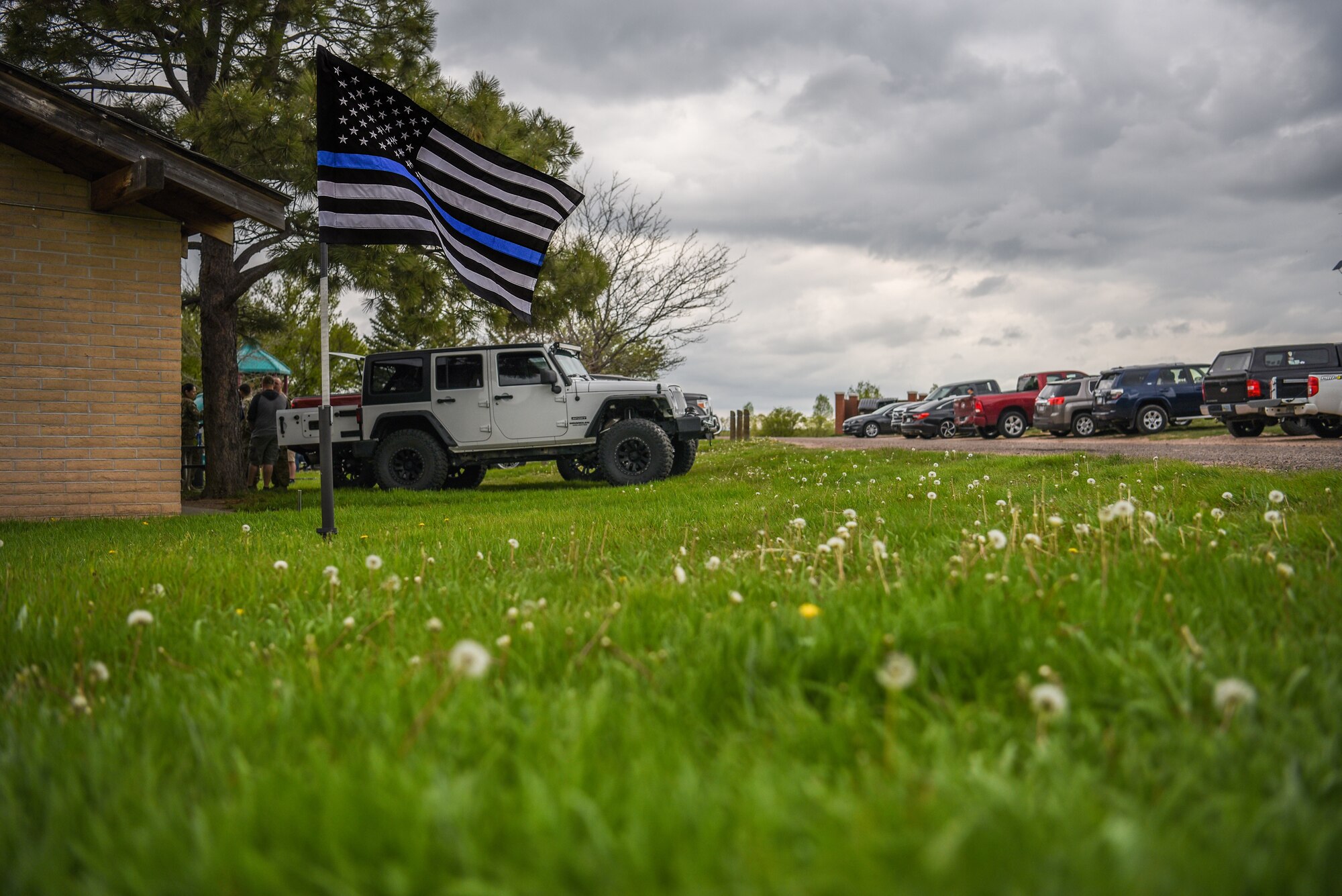 The Thin Blue Line Flag waves in the wind during a barbecue for the closing of Police Week, May 18, 2018, on F.E. Warren Air Force Base, Wyo. Police Week concluded with festivities for Airmen and families to unwind after a week of events and work. In 1962, President John F. Kennedy signed a proclamation which designated May 15 as Peace Officers Memorial Day and the week in which that date falls as Police Week. People all across the United States participate in various events which honor those have paid the ultimate sacrifice. (U.S. Air Force photo by Airman 1st Class Braydon Williams)