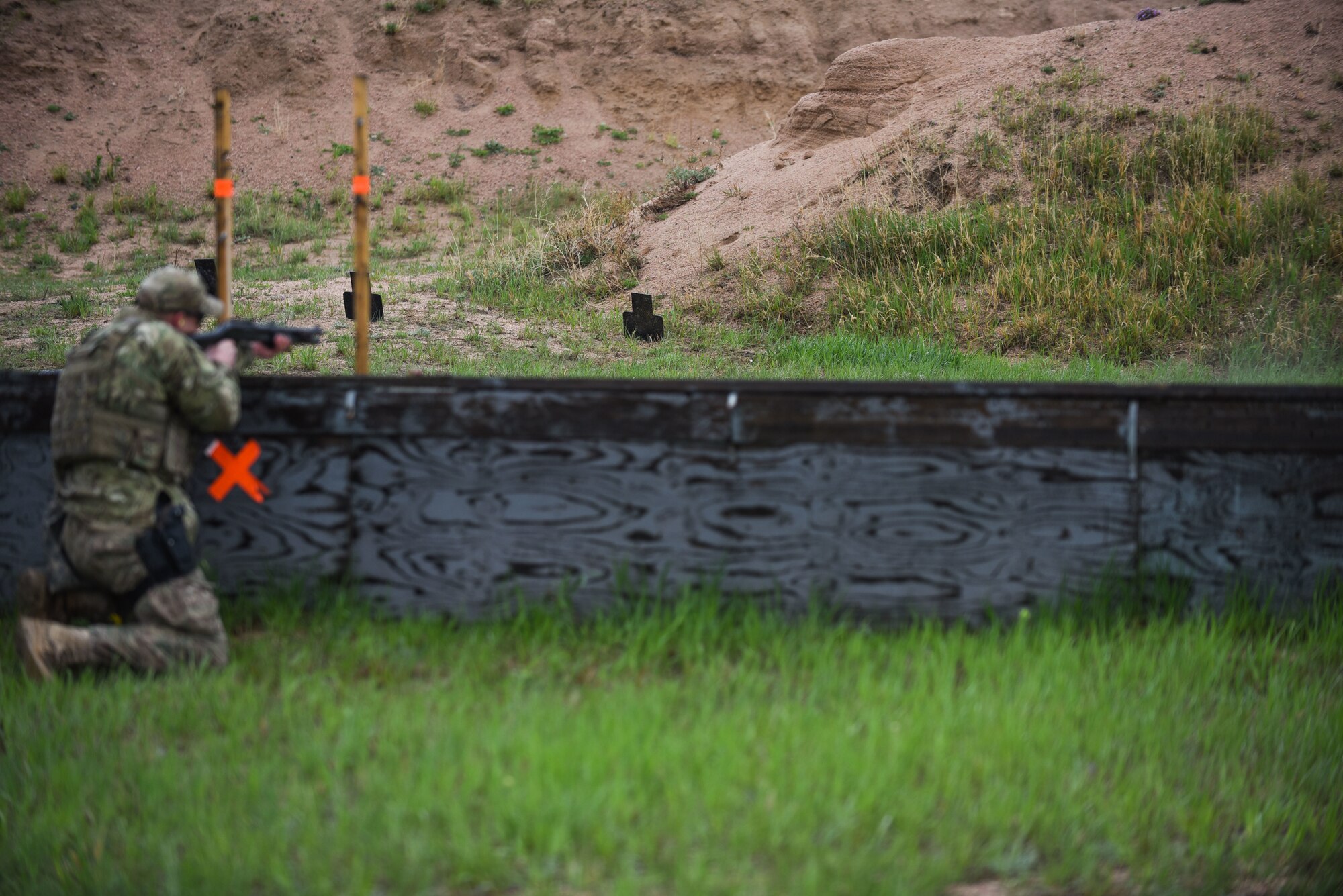 Staff Sgt. Kyle Snape, 90th Security Forces Squadron military working dog handler, aims down-range during a three-gun competition at the Cheyenne police department firing range in Laramie County, Wyo. A three-gun competition consists of a set of courses in which you shoot three different weapons—a rifle, a pistol and a shotgun—at different stages, and engage various short- and long-distance targets from multiple positions. Scoring is based on time and hits minus penalties, with each stage assigned match points based on a degree of difficulty. In 1962, President John F. Kennedy signed a proclamation which designated May 15 as Peace Officers Memorial Day and the week in which that date falls as Police Week. People all across the United States participate in various events which honor those who have paid the ultimate sacrifice. (U.S. Air Force photo by Airman 1st Class Braydon Williams)