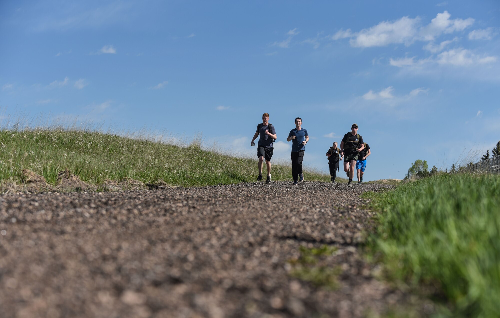 Airmen from the 90th Communications Squadron and 90th Security Forces Group approach the finish line of the six-mile run, walk or ruck for police week, May 17, 2018, on F.E. Warren Air Force Base, Wyo. The Police Week run, walk or ruck was a six-mile course around the northern perimeter of the base. Airmen could either participate or compete for fastest time. To place, their ruck had to weigh at least 35 pounds. In 1962, President John F. Kennedy signed a proclamation which designated May 15 as Peace Officers Memorial Day and the week in which that date falls as Police Week. People all across the United States participate in various events which honor those who have paid the ultimate sacrifice. (U.S. Air Force photo by Airman 1st Class Braydon Williams)