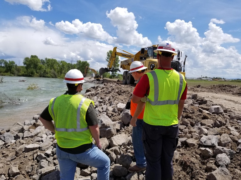 USACE Walla Walla District engineers Andy Rajala (left) and Michael Schaffer (middle) and Kent Bernard, a USACE contracting specialist (right), monitor contractors' emergency repair work, May 20, on an eroded area of the Heise-Roberts Levee System on the Snake River near Lorenzo, Idaho. As of Sunday afternoon (May 20), contractors have repaired about two-thirds of the 300-feet-long by 15-feet-wide section of levee eroded away by seasonal high flows in the Snake River. In some locations the levee has been eroded more than 20 feet in height from the top of the levee -- about 8 feet of the levee is visible above the water’s surface.