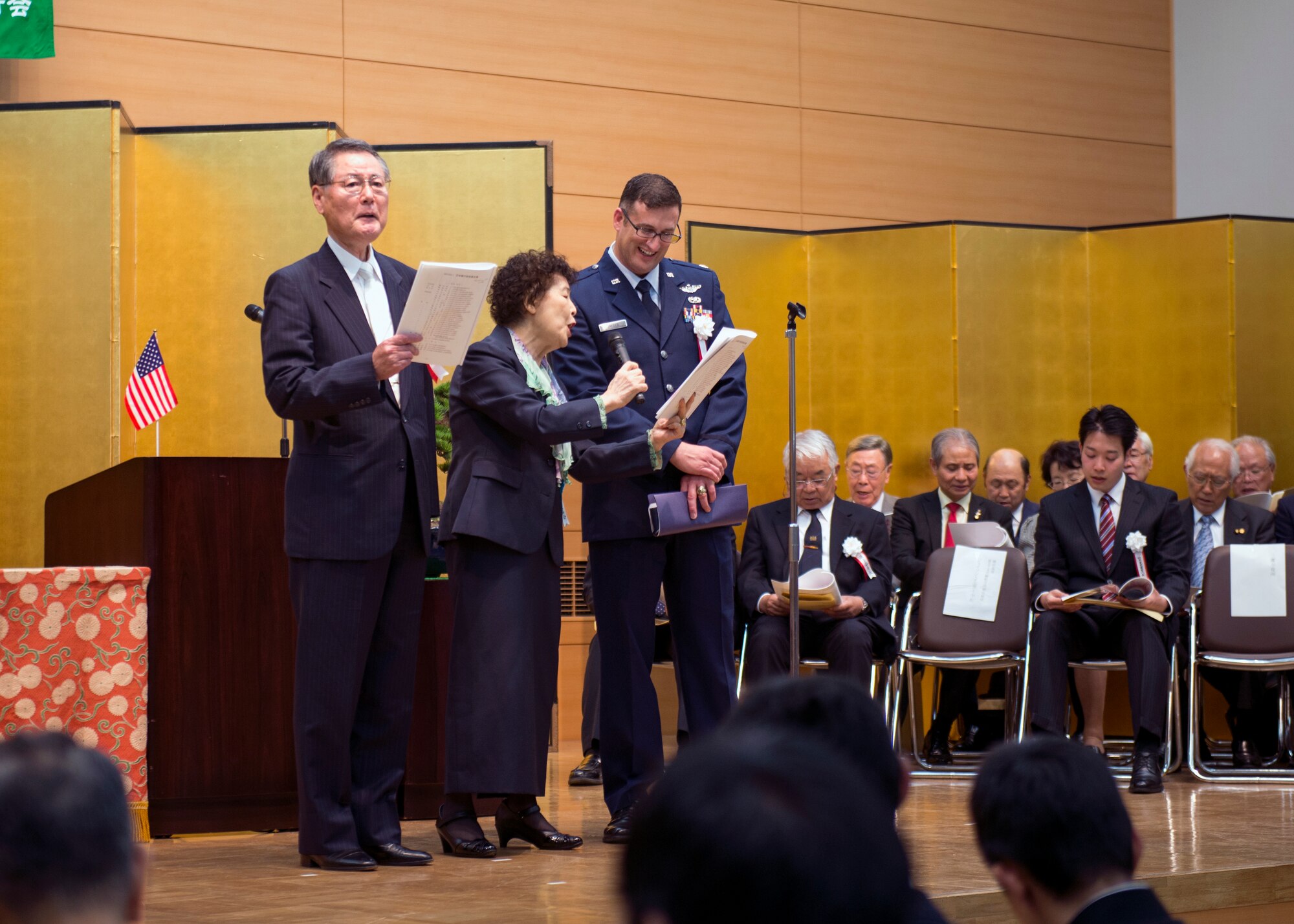 Lt. Col. Jason Jaeger, 374th Airlift Wing director of staff, (right) and Kensuke Katuno, Good Deed Association president, (left) sing