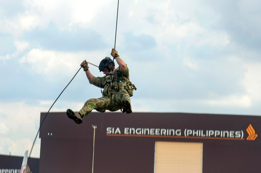 An airman rappels from an HH-60 Pave Hawk helicopter.