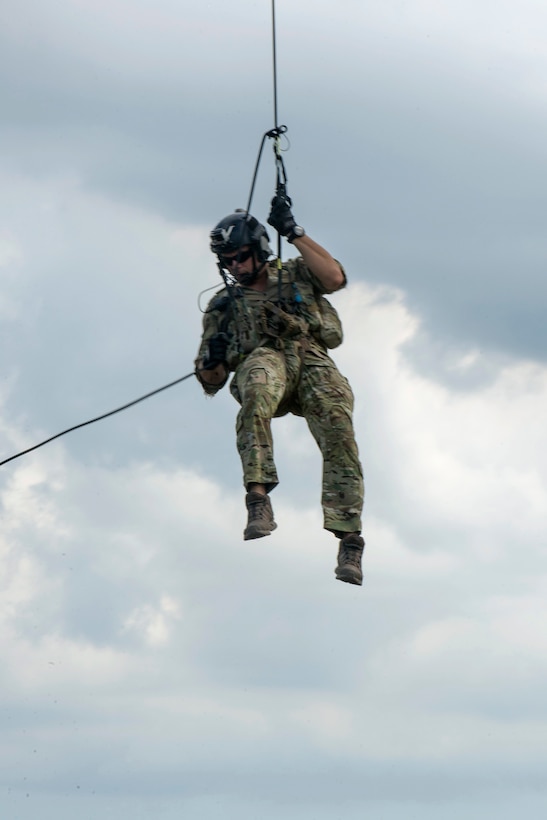 An airman rappels from an HH-60 Pave Hawk helicopter.