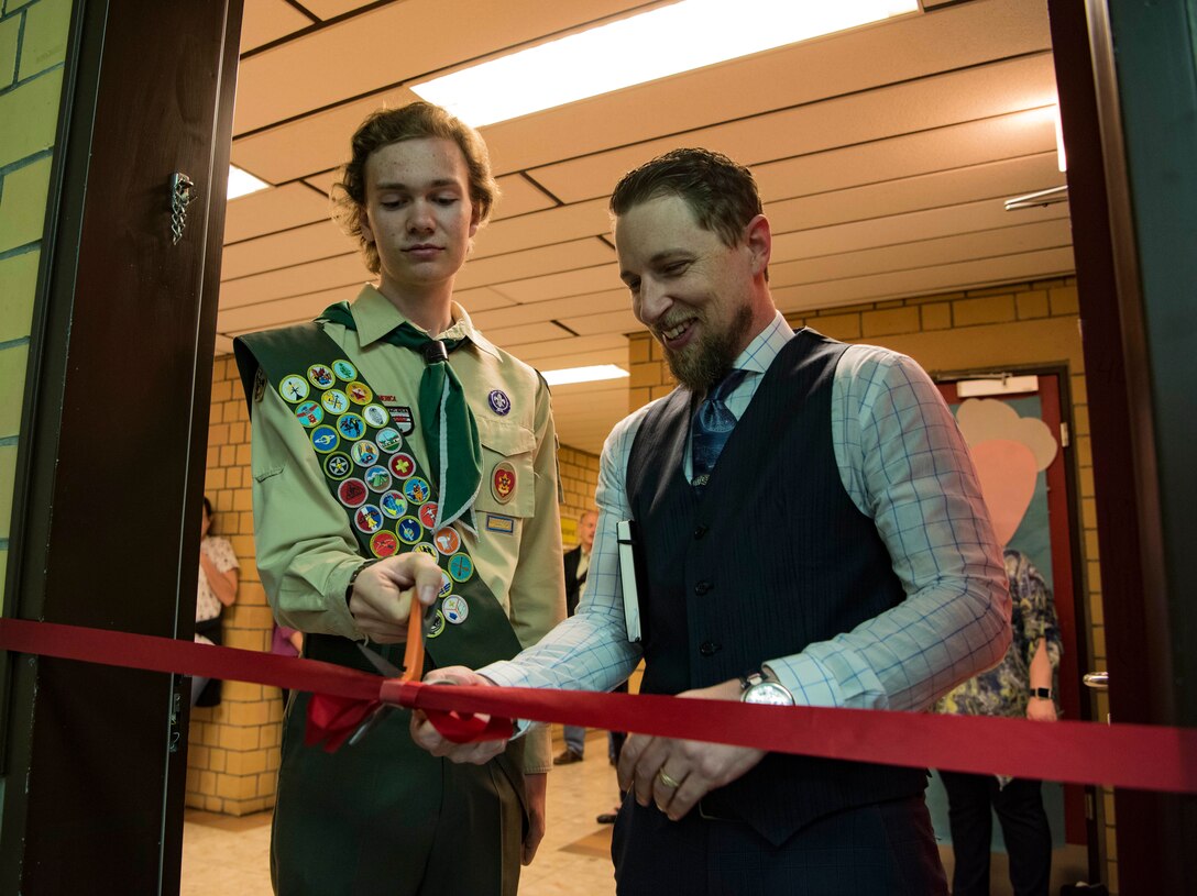 Louis Roscoe, a Boy Scouts of America Life Scout (second highest rank in BSA) and student at Kaiserslautern High School, and David Lee, Vogelweh Elementary School principal, cut the red-ribbon for the sensory room at Vogelweh Elementary School on Vogelweh Military Complex, Germany, May 15, 2018. With the help of friends and family, Roscoe was able to raise over $13,000 for the sensory room.