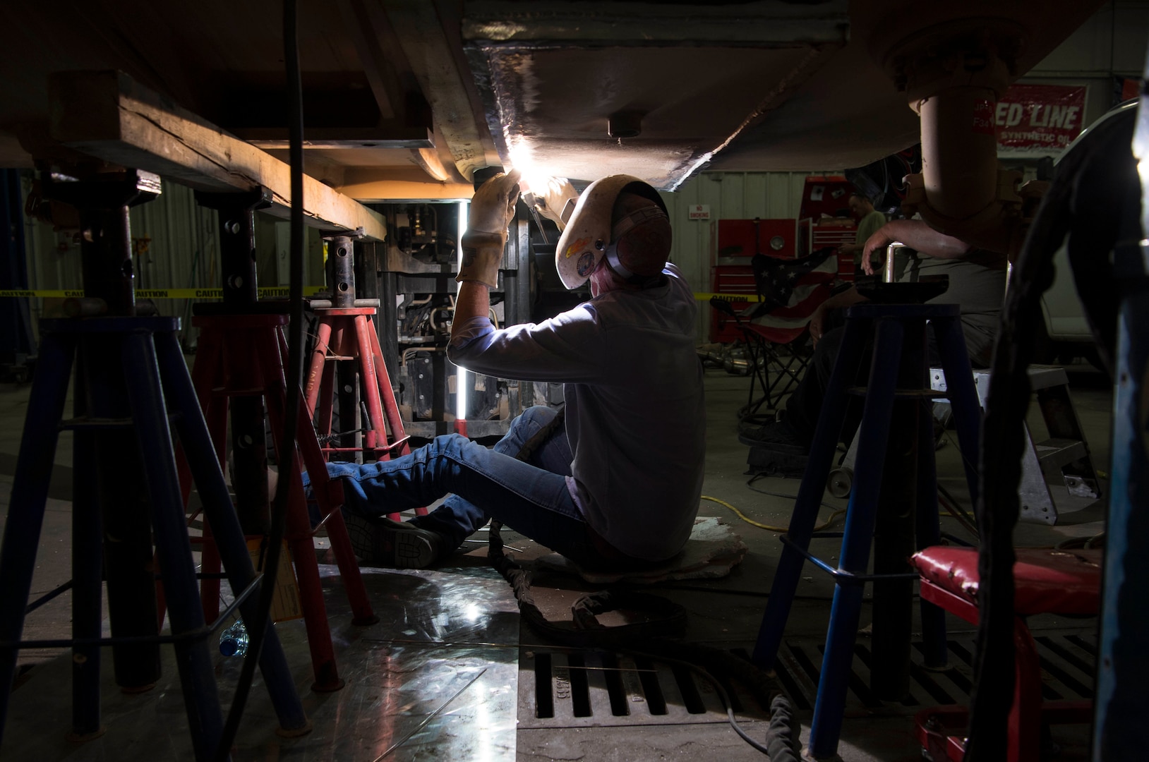 Mark Flannery, a welder from Detachment 6 at Al Udeid Air Base, Qatar, welds a steel plate to the bottom of a Jet Petroleum 8 tank in a vehicle management garage at an undisclosed location in Southwest Asia, April 27, 2018. Flannery was hand selected to come and repair the tank. (U.S. Air Force photo by Staff Sgt. Joshua King)