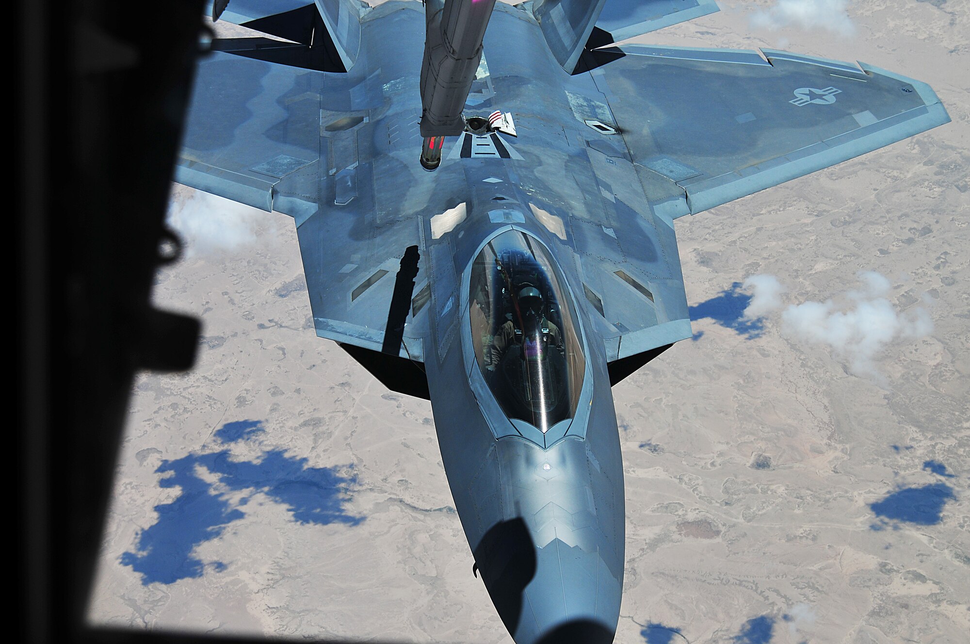 A 94th Fighter Squadron F-22 Raptor at the 380th Air Expeditionary Wing, Al Dhafra Air Base approaches a KC-10 Extender refueling aircraft operated by the 908th Air Refueling Squadron over the skies of Southwest Asia, May 16, 2018.  Air refueling is a vital component of flying operations, allowing the F-22 to stay airborne longer and support U.S. and coalition forces in the air and on the ground as a part of Operation Inherent Resolve.