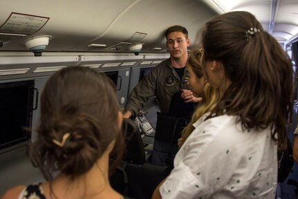 Aviation Warfare Systems (Operator) 2nd Class Joshua Grant, from Jacksonville, Fla., assigned to the "Skinny Dragons" of Patrol Squadron (VP) 4, gives a tour of the interior of a P-8A Poseidon aircraft to students from the American School in Japan. The students were in Okinawa to learn about the U.S. Navy’s and the Japan Maritime Self-Defense Force’s (JMSDF) roles, capabilities and missions.