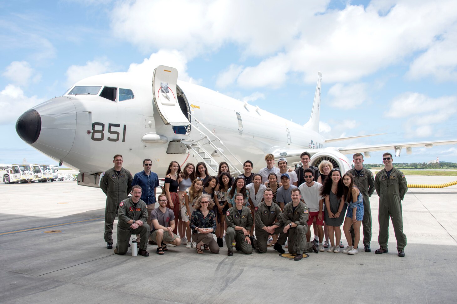 Sailors assigned to the "Skinny Dragons" of Patrol Squadron (VP) 4, pose for a photo with students and teachers from the American School in Japan. The students were in Okinawa to learn about the U.S. Navy’s and the Japan Maritime Self-Defense Force’s (JMSDF) roles, capabilities and missions.