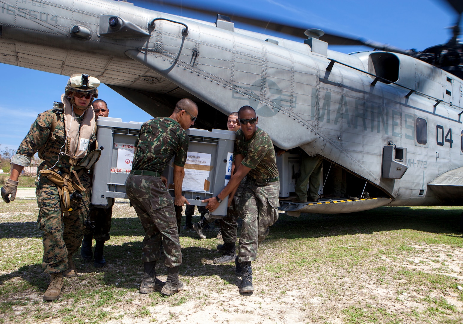 U.S. Marine Sgt. Jordan Becker, left, a cyber network specialist with Joint Task Force Matthew, offloads a generator from a CH-53E Super Stallion helicopter with the help of the Brazilian service members at Jeremie, Haiti, Oct. 15, 2016. After eight days of supply drop operations JTF Matthew has delivered over 478,000 pounds of supplies utilizing various military aircraft. JTF Matthew, a U.S. Southern Command-directed team comprised of Marines, soldiers, sailors and airmen, is providing critical airlift capabilities during the initial stages of the U.S. Agency for International Development's disaster relief operations in Haiti while the international response builds.