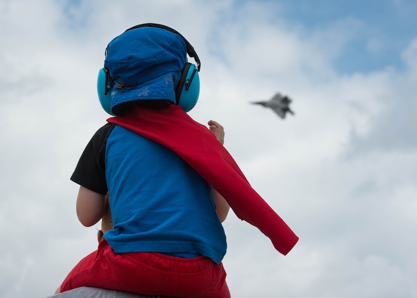 A child watches U.S. Air Force Maj. Paul “Loco” Lopez, F-22 Raptor Demonstration Team commander and pilot, perform during the AirPower Over Hampton Roads JBLE Air and Space Expo at Joint Base Langley-Eustis, Virginia, May 20, 2018.