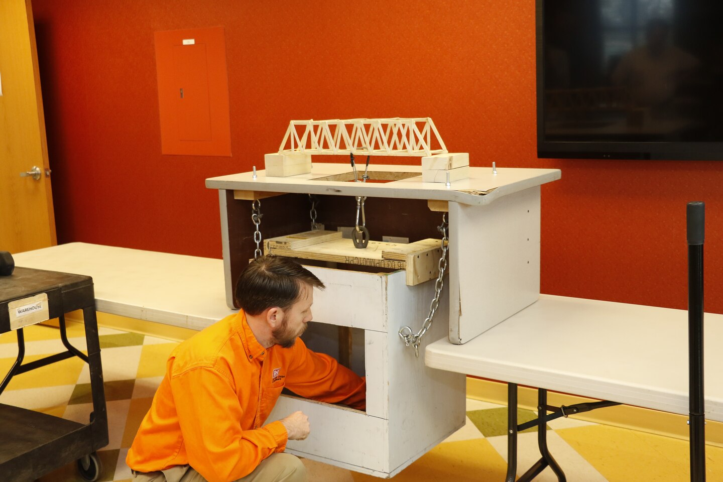 Architectural Engineering Technician Scott Trammell adds weight to the bridge constructed by high school intern Josh Dalton during his Gifted and Independent Study class while interning at the Middle East District.