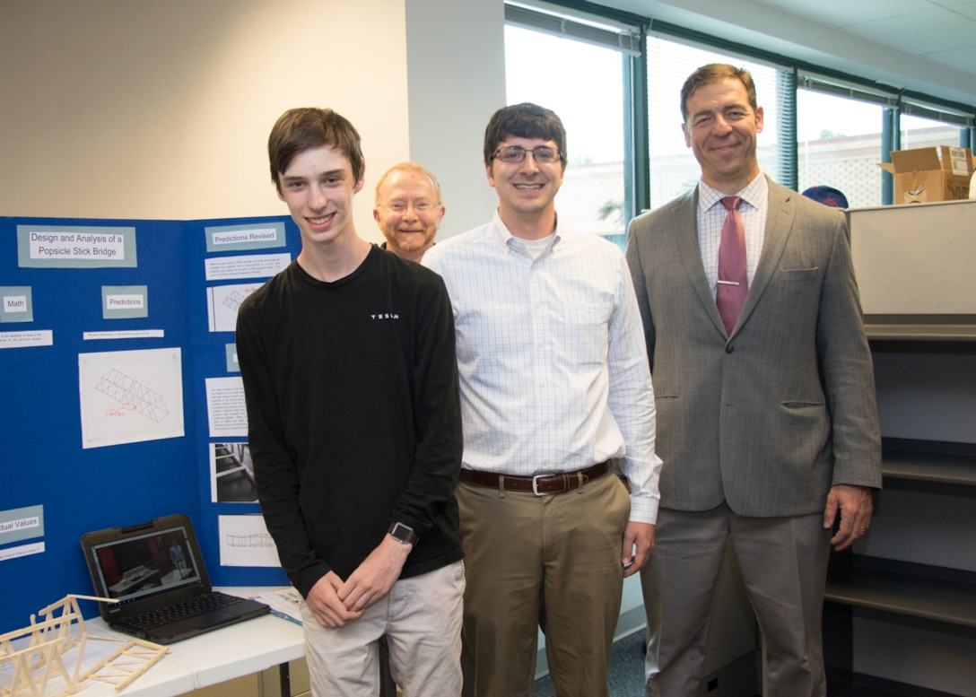 Local high school junior Josh Dalton, with his mentor Structural Engineer Nathan Fox, and Engineering Division Chief Alan Zytowski with Chief of Engineering Division’s Site and Building Design Branch in the back.