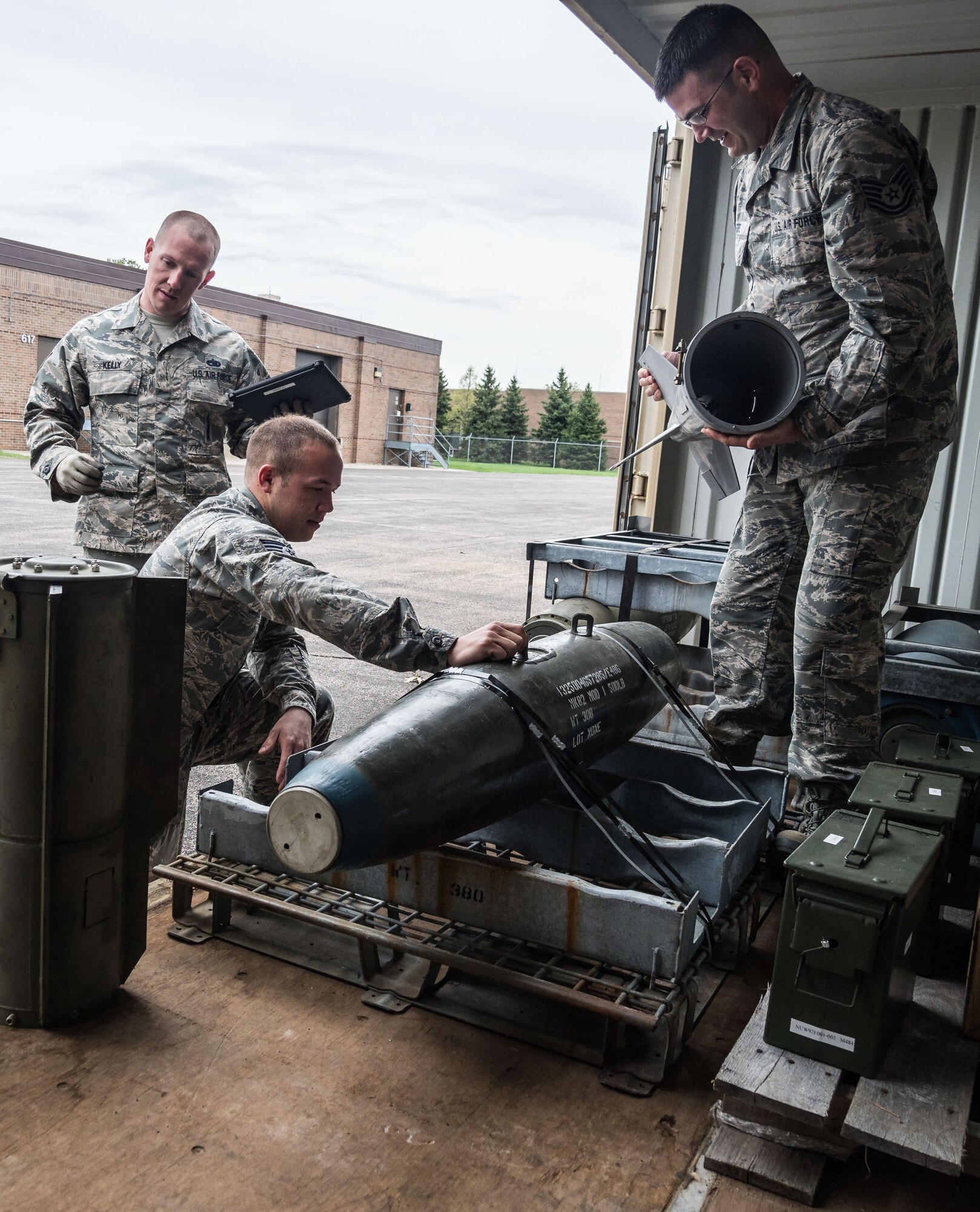 From left, Staff Sgt. Ryan Kelly, Staff Sgt. Andrew Johnson and Tech. Sgt. Matthew Fors inspect 500 pound bombs used for training by Explosive Ordnance Disposal. (Air Force Photo/Paul Zadach)