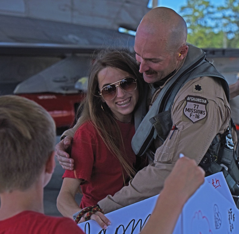U.S. Air Force Lt. Col. James Buessing, 77th Fighter Squadron (FS) commander, greets his daughter with a hug upon his return to Shaw Air Force Base, S.C.
