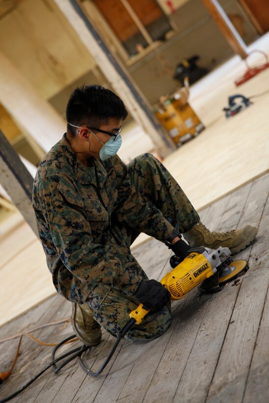 U.S. Marine Private First Class William Padilla, combat engineer with Bridge Company A, 6th Engineer Support Battalion, 4th Marine Logistics Group, uses a grinder to level out the ground at a construction site during exercise Red Dagger at Fort Indiantown Gap, Pa., May 21, 2018.