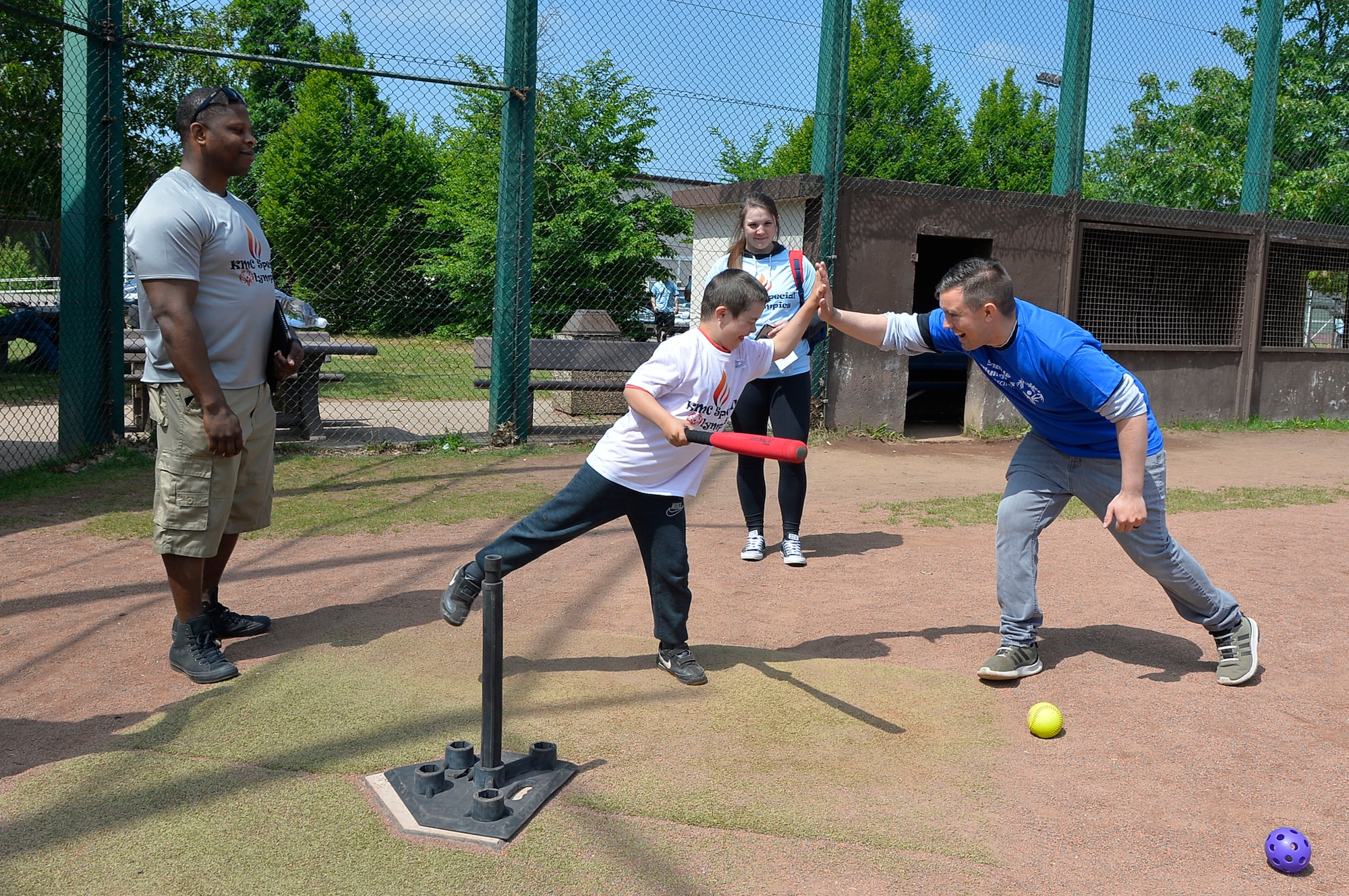 Senior Airman Michael Therrien, 86th Maintenance Squadron aerospace ground equipment technician, far right, congratulates a Kaiserslautern Military Community Summer Special Olympian on Ramstein Air Base, Germany, May 18, 2018. Games at the event included soccer ball kicking, football throwing, basketball shooting, homerun derby, and running. (U.S. Air Force photo by Senior Airman Joshua Magbanua)