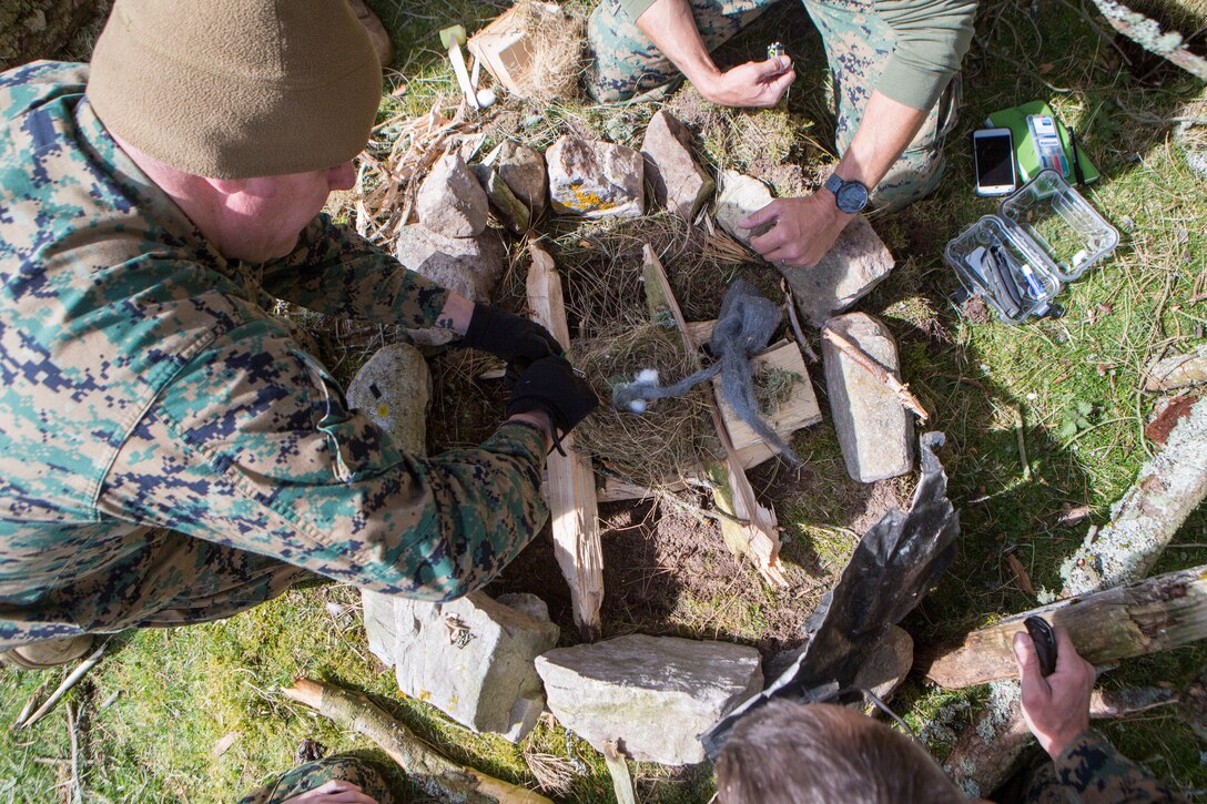 U.S. Navy Chief Petty Officer Rafael Corrada, corpsman with 4th Air Naval Gunfire Liaison Company, Force Headquarters Group, begins the process of starting a fire during survival training, in Durness, Scotland, April 26, 2018.