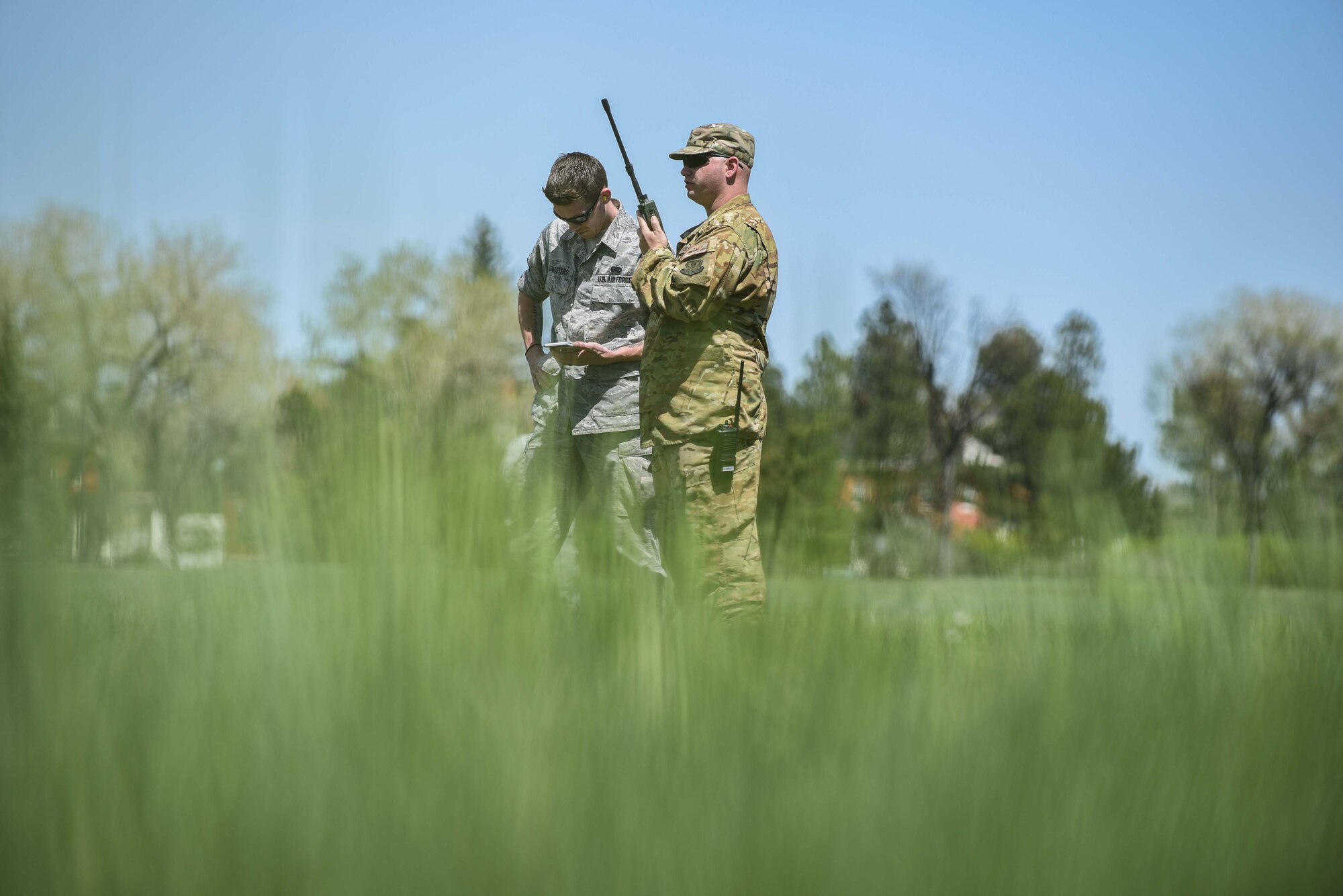 Staff Sgt. Andrew Leemasters, 790th Missile Maintenance Squadron decentralized material support technician, and Tech. Sgt. Christopher Rector, 37th Helicopter Squadron NCO in charge of plans and programs, radio for helicopter assistance during a pre-planned scenario, May 19, 2018, on F.E. Warren Air Force Base, Wyo. Helicopter assistance was part of a casualty evacuation scenario during 90th Mission Support Group’s Warrior Day. The Warrior Day was an all-day training event to reinforce deployment preparedness, warrior ethos and a commitment to teamwork. (U.S. Air Force photo by Airman 1st Class Abbigayle Wagner)