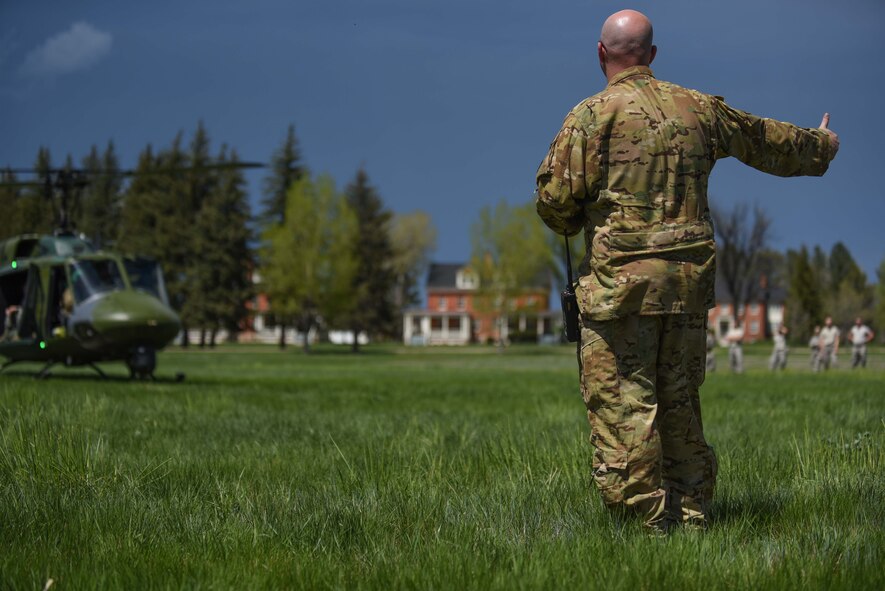 Technical Sgt. Christopher Rector, 37th Helicopter Squadron NCO in charge of plans and programs, gives a thumbs up to the helicopter pilot for takeoff, May 19, 2018, on F.E. Warren Air Force Base, Wyo. As part of the 90th Mission Support Group’s Warrior Day, Airmen received an incentive flight followed by a tour and a sample mission brief from 582nd Helicopter Group personnel. The Warrior Day was an all-day training event to reinforce deployment preparedness, warrior ethos and a commitment to teamwork. (U.S. Air Force photo by Airman 1st Class Abbigayle Wagner)