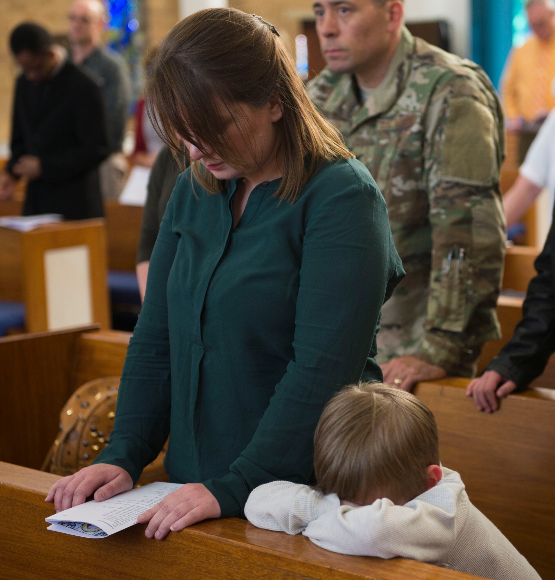 A mother and her son bow their heads in prayer during the final Catholic mass at RAF Mildenhall, England, May 14, 2018. The Catholic Parish falls under Our Lady of Walsingham Catholic Community, and has been a part of RAF Mildenhall since 1955. (U.S. Air Force photo by Airman 1st Class Alexandria Lee)
