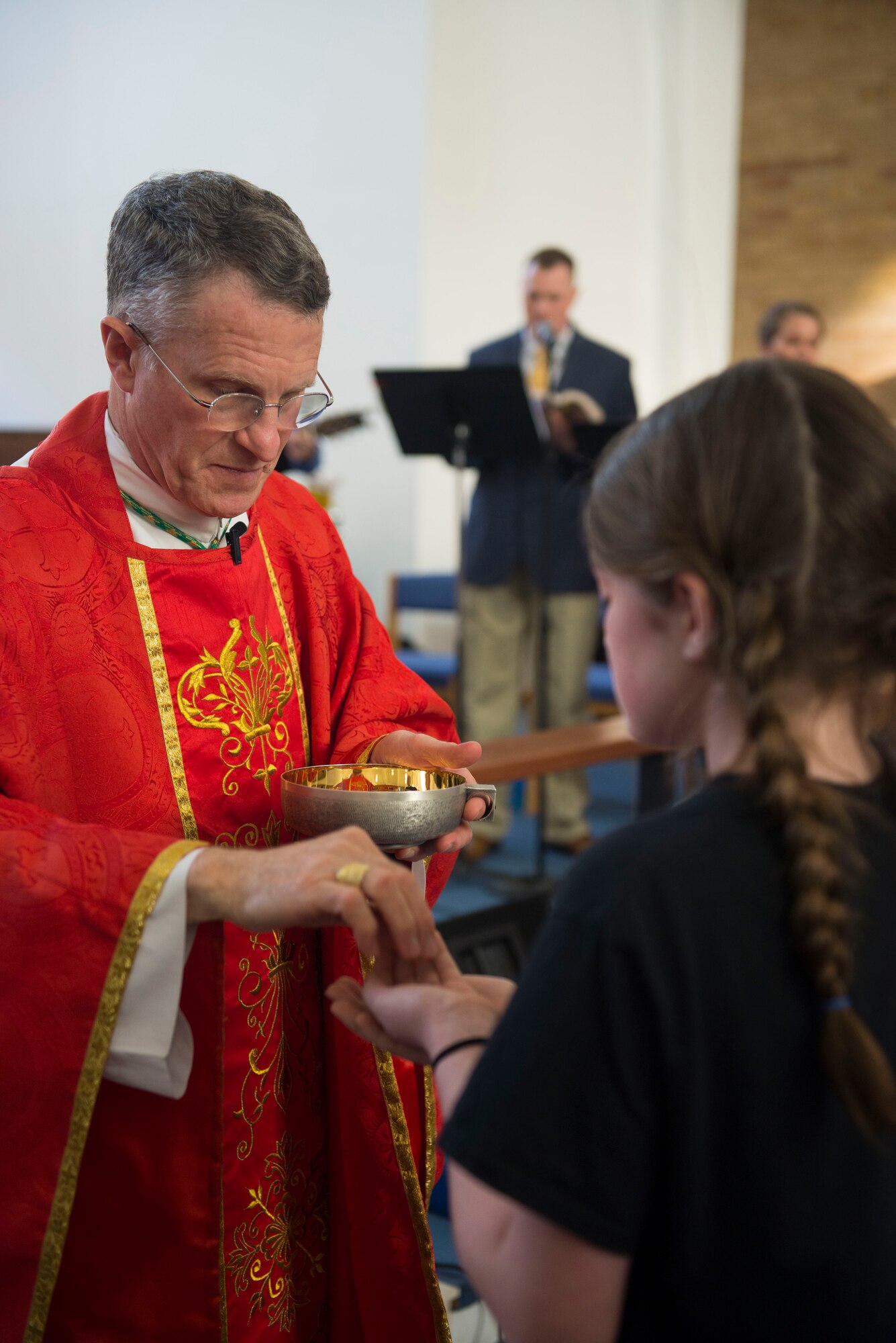 Archbishop for the Military Services Timothy Broglio gives communion to a child during the final catholic mass at RAF Mildenhall, England, May 14, 2018. Broglio visited RAF Mildenhall to give one last sermon before the move to RAF Lakenheath. (U.S. Air Force photo by Airman 1st Class Alexandria Lee)